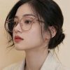 Mẫu nữ đeo kính gọng tròn màu hồng trong suốt thời trang Lumi Eyewear tôn dáng mặt.