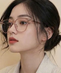 Mẫu nữ đeo kính gọng tròn màu hồng trong suốt thời trang Lumi Eyewear tôn dáng mặt.