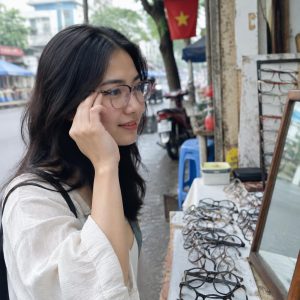 Người phụ nữ đang thử các kiểu gọng kính phù hợp khuôn mặt khác nhau