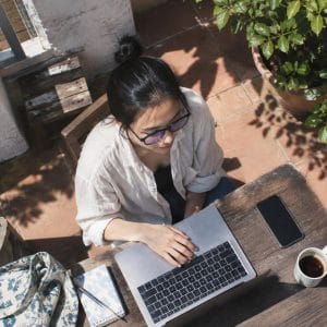 Một người đeo kính cho người dùng máy tính đang làm việc trên máy tính xách tay